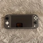 Nintendo Switch Lite Gray Console W/ Hot Wheels, Justice League Games, Cases Used. Price: $139.00.