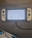 Unpatched Nintendo Switch With White Controllers Used. Price: $160.00.