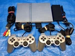Sony Playstation Slim Silver Console + PS2 Controllers All Cables Used. Price: $249.99.